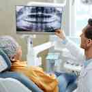 Ein Zahnarzt zeigt einer Patientin ein Röntgenbild von ihrem Kiefer.
