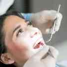 Eine Frau ist beim Zahnarzt und wird untersucht. 