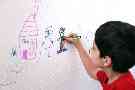 Ein Junge malt auf eine Tapete - Haftungsrisiken bei Kindern absichern