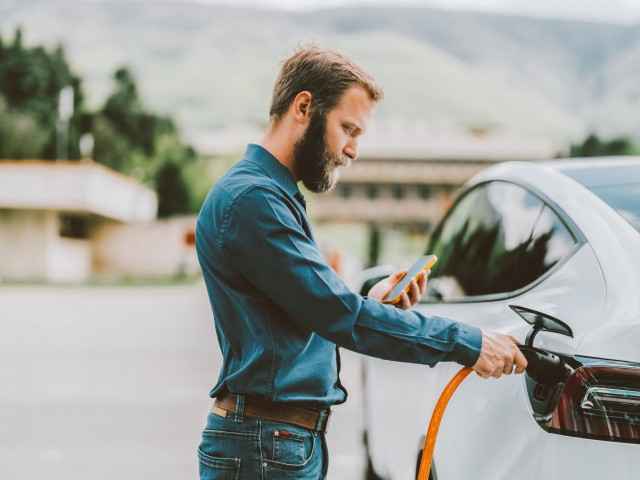 Ein Mann lädt ein Elektroauto