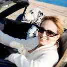 Frau mit einem Hund im Cabrio.