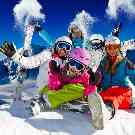 Eine Familie im ersten Skiurlaub auf einem schneebedenkten Berg.