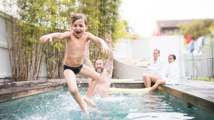 Kind springt in den Pool Kind springt in den Pool
