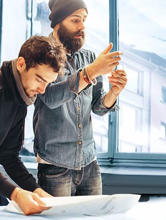 Berufsunfähigkeitsversicherung: Junge Menschen diskutieren bei der Arbeit. Berufsunfähigkeitsversicherung: Junge Menschen diskutieren bei der Arbeit.