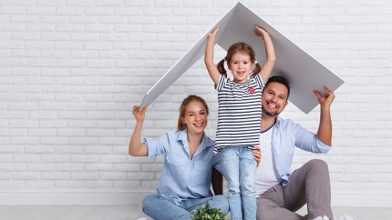 Bausparen: Vater, Mutter und Tochter stellen symbolisch mit einem Dach, das sie über sich halten, das Haus dar, in dem sie wohnen wollen. Bausparen: Vater, Mutter und Tochter stellen symbolisch mit einem Dach, das sie über sich halten, das Haus dar, in dem sie wohnen wollen.