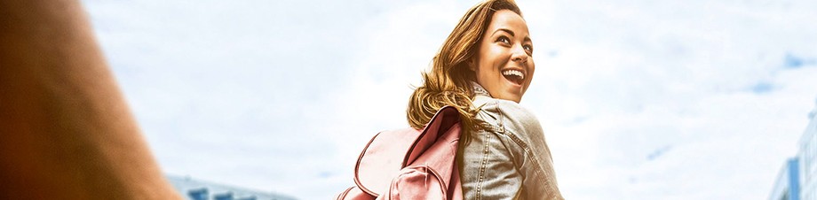 Private Haftpflichtversicherung: Junge Frau fährt lachend auf einem Rad. Private Haftpflichtversicherung: Junge Frau fährt lachend auf einem Rad.