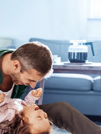Hausratversicherung: Familie spielt im Wohnzimmer. Hausratversicherung: Familie spielt im Wohnzimmer.
