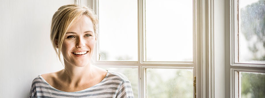 Versicherung Haus und Wohnung: Frau in ihrem Haus freut sich, dass ihr Gebäude inklusive Hausrat rundum versichert ist. Versicherung Haus und Wohnung: Frau in ihrem Haus freut sich, dass ihr Gebäude inklusive Hausrat rundum versichert ist.