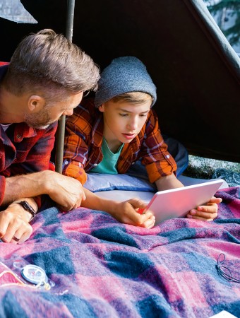 Gothaer Wohngebäudeversicherung: Vater und Sohn zelten im Garten. Gothaer Wohngebäudeversicherung: Vater und Sohn zelten im Garten.
