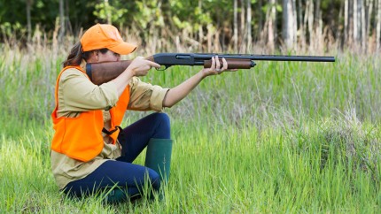Gothaer Jagdwaffenversicherung und Sportwaffenversicherung: Jägerin mit Gewehr auf der Jagd im Wald. Gothaer Jagdwaffenversicherung und Sportwaffenversicherung: Jägerin mit Gewehr auf der Jagd im Wald.