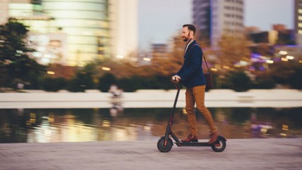 Mann fährt auf einem E-Scooter Mann fährt auf einem E-Scooter