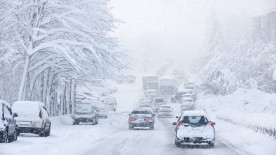 Autos im Schneetreiben auf einer stark befahrenen Straße Autos im Schneetreiben auf einer stark befahrenen Straße