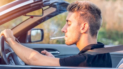 Brandschutz im Auto: Junger Mann mit Zigarette im Auto Brandschutz im Auto: Junger Mann mit Zigarette im Auto