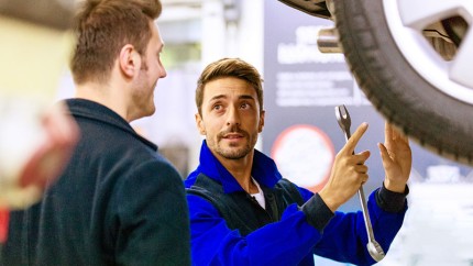 Frühjahrscheck: KFZ-Mechaniker spricht mit Kunden Frühjahrscheck: KFZ-Mechaniker spricht mit Kunden