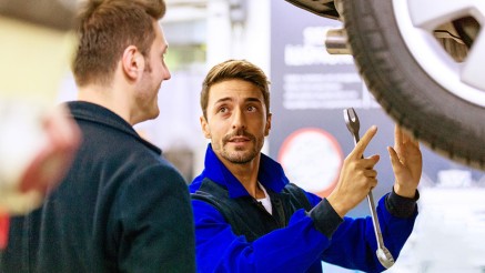 Frühjahrscheck: KFZ-Mechaniker spricht mit Kunden Frühjahrscheck: KFZ-Mechaniker spricht mit Kunden