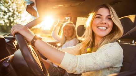 Vollkasko: Junge Frau mit Beifahrerin im Auto Vollkasko: Junge Frau mit Beifahrerin im Auto