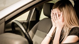 Frau im Auto schlägt die Hände vors Gesicht Frau im Auto schlägt die Hände vors Gesicht