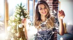Ratgeber Brandschutz: Frau mit Lichterkette vor dem Weihnachtsbaum Ratgeber Brandschutz: Frau mit Lichterkette vor dem Weihnachtsbaum