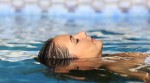 Frau liegt auf dem Rücken im Wasser Frau liegt auf dem Rücken im Wasser