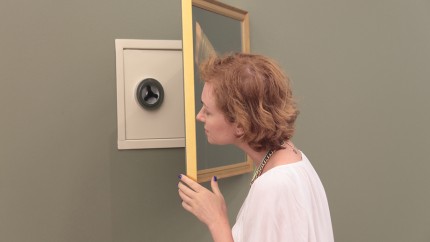 Sicherungsrichtlinien: Eine Frau versteckt ihren Safe hinter einem Bild. Sicherungsrichtlinien: Eine Frau versteckt ihren Safe hinter einem Bild.